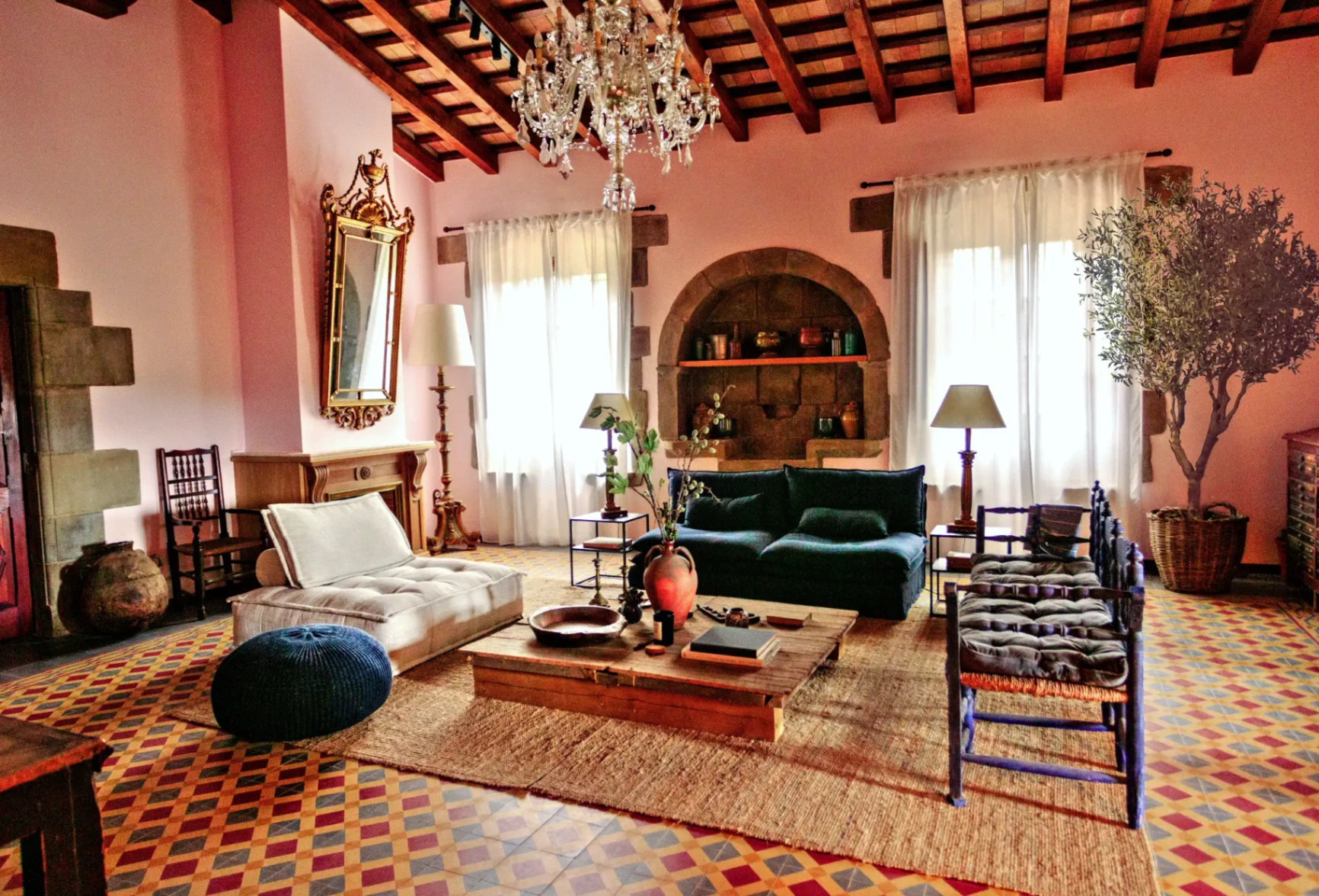 Espacio común con paredes rosadas, lámpara de cristal y decoración cálida